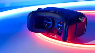 Close-up of a black virtual reality headset, illuminated by glowing red and blue lights.