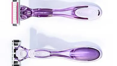 Two purple and white razors on a white background, one facing forward, one backward.